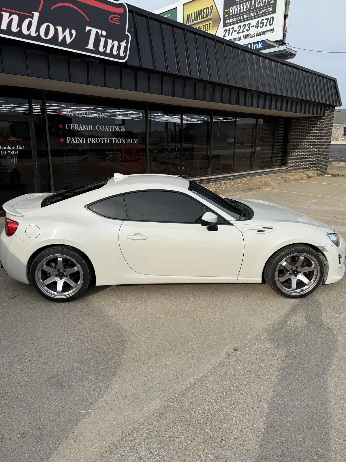 White coupe with finished window tint outside Pristine Window Tint in Quincy, Illinois